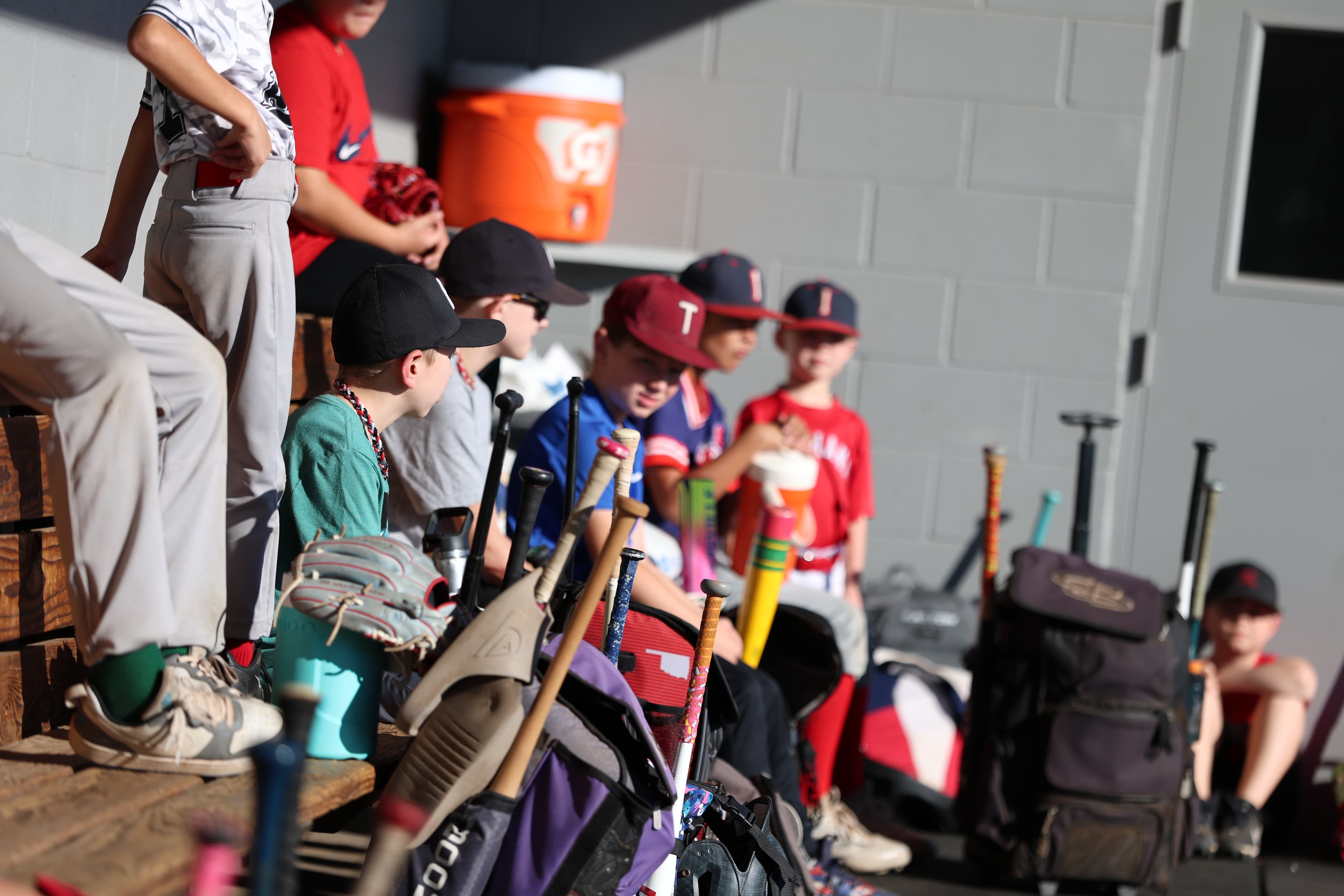 Bats, gloves, and Fall Camp players along the dugout bench