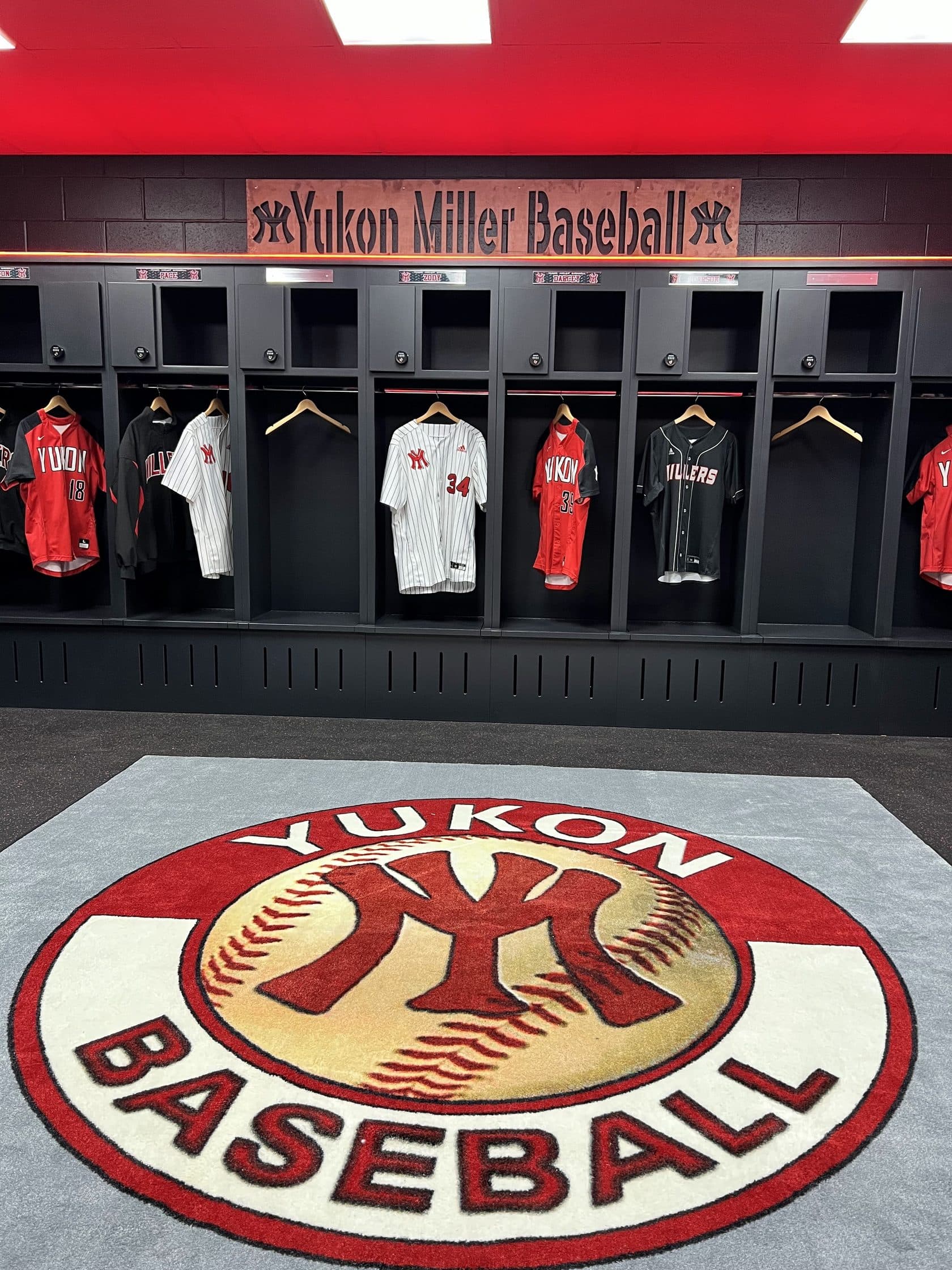 Yukon home, road, and pinstripe jerseys hanging above the YM baseball rug