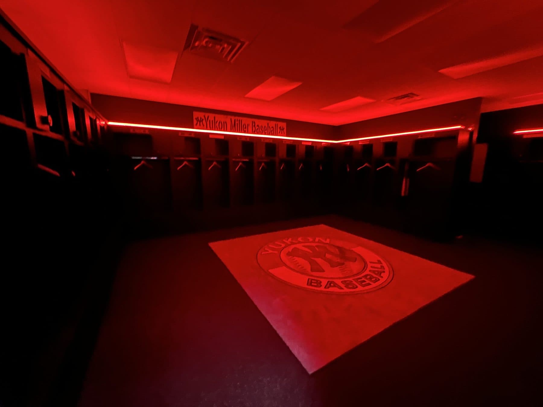Yukon Miller clubhouse under red light with the YM rug in the center