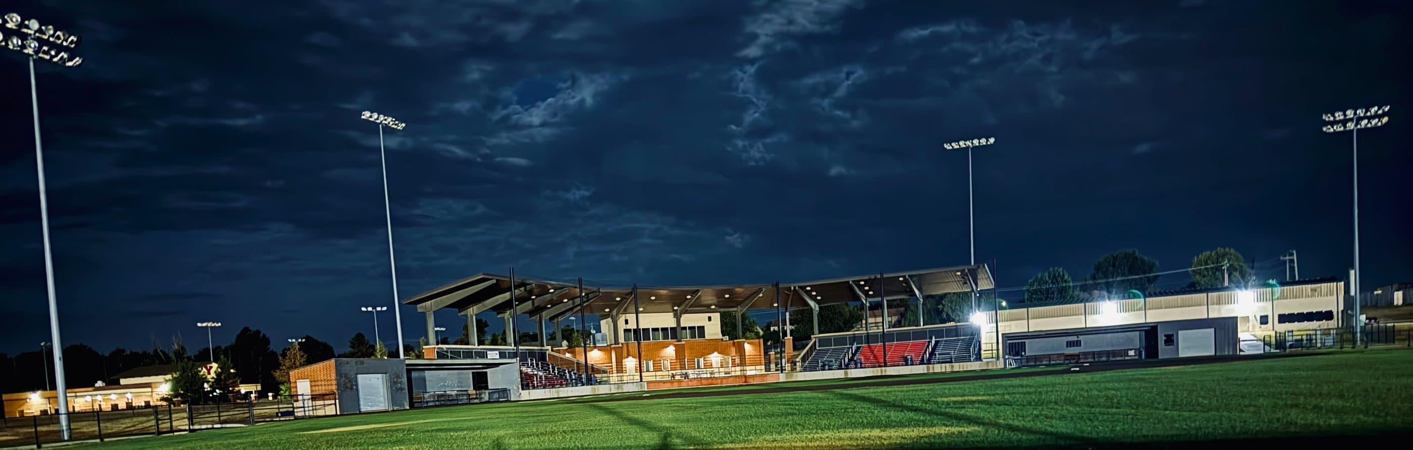 Miller Field at night with the lights on over the grandstand and turf