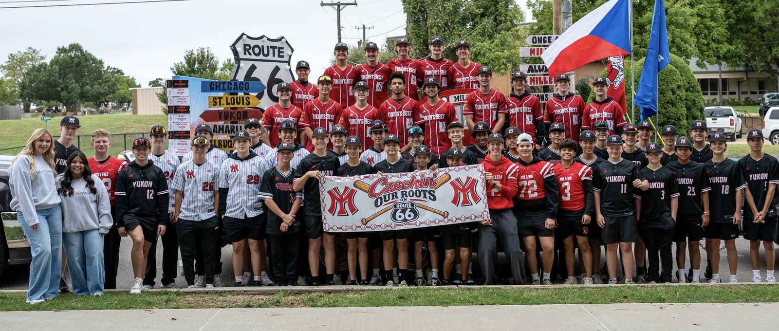 The Yukon Miller Baseball program together in front of the Czech Festival Parade float and Czechin’ Our Roots banner
