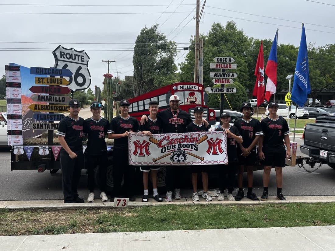 Yukon Miller Baseball players in black uniforms with the Czechin’ Our Roots banner