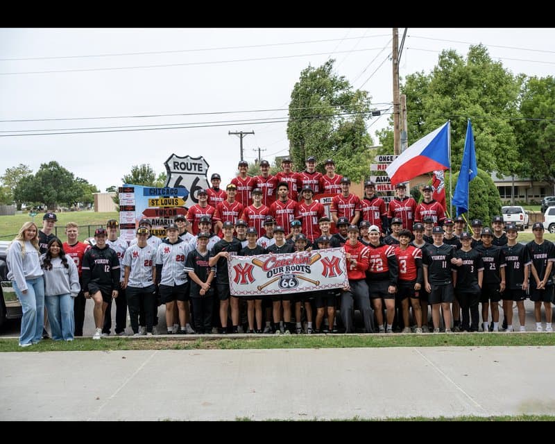 The Yukon Miller Baseball program together in front of the Czech Festival Parade float and Czechin’ Our Roots banner