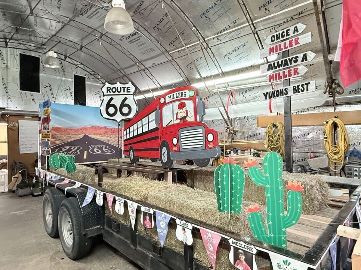 The Yukon Baseball Czech Festival Parade float with hay bales, cactuses, Route 66 signs, and a Millers school bus