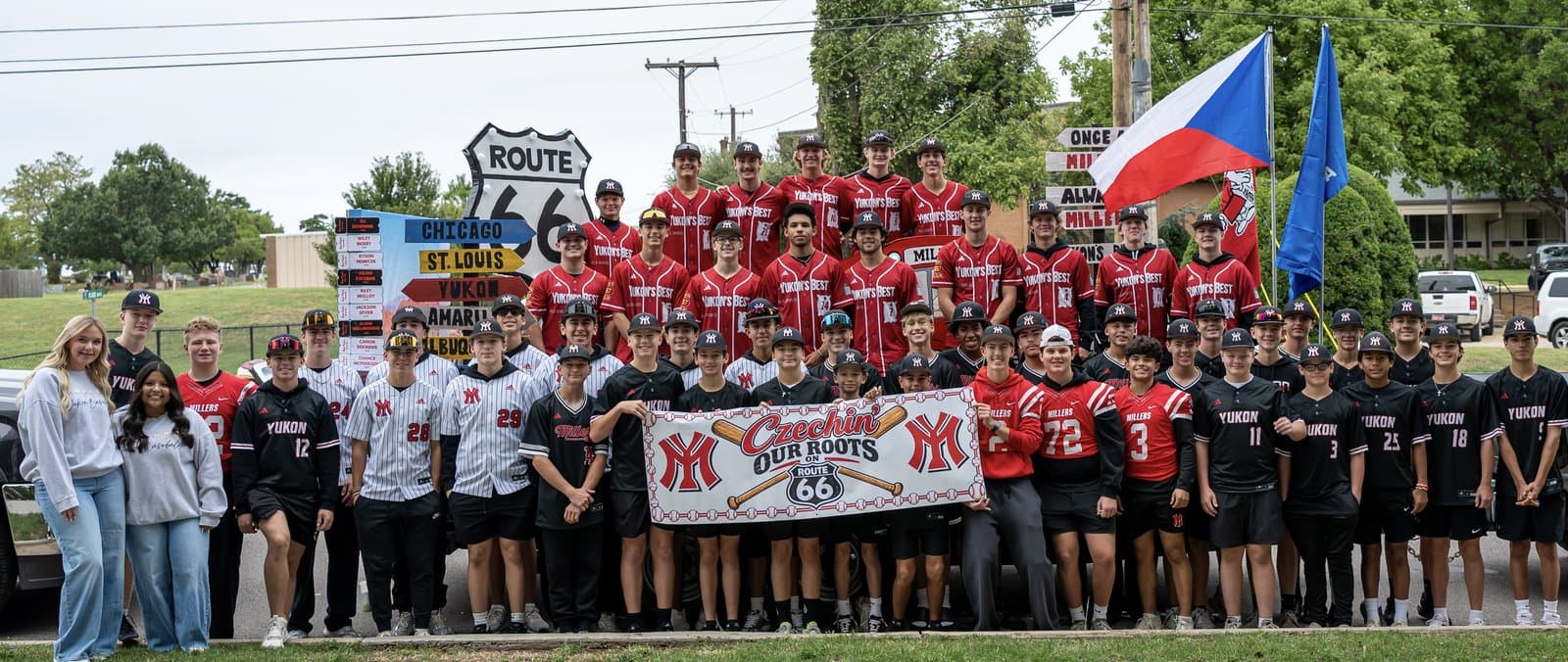The Yukon Miller Baseball program together in front of the Czech Festival Parade float and Czechin’ Our Roots banner