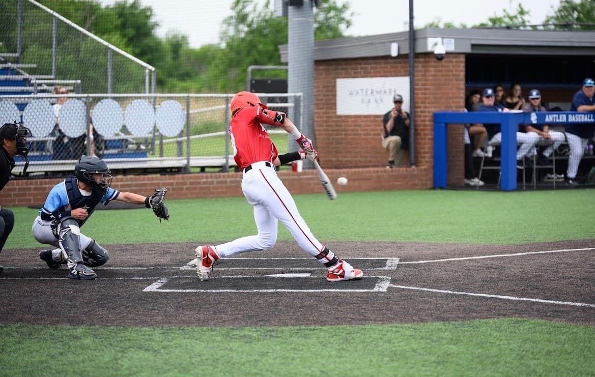 Drake Pace swinging through a pitch in a Yukon Miller uniform