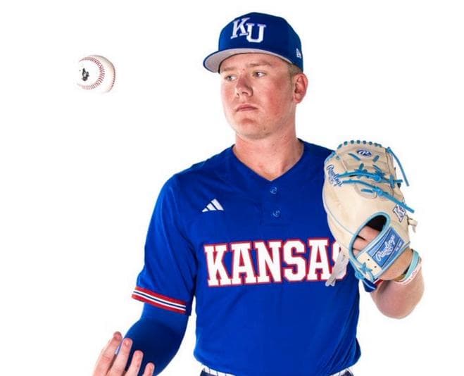 Grady Hoke in a Kansas uniform, holding a glove with a baseball in the air