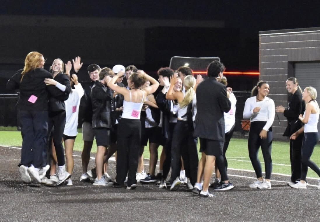Powder Puff players celebrate together on the infield